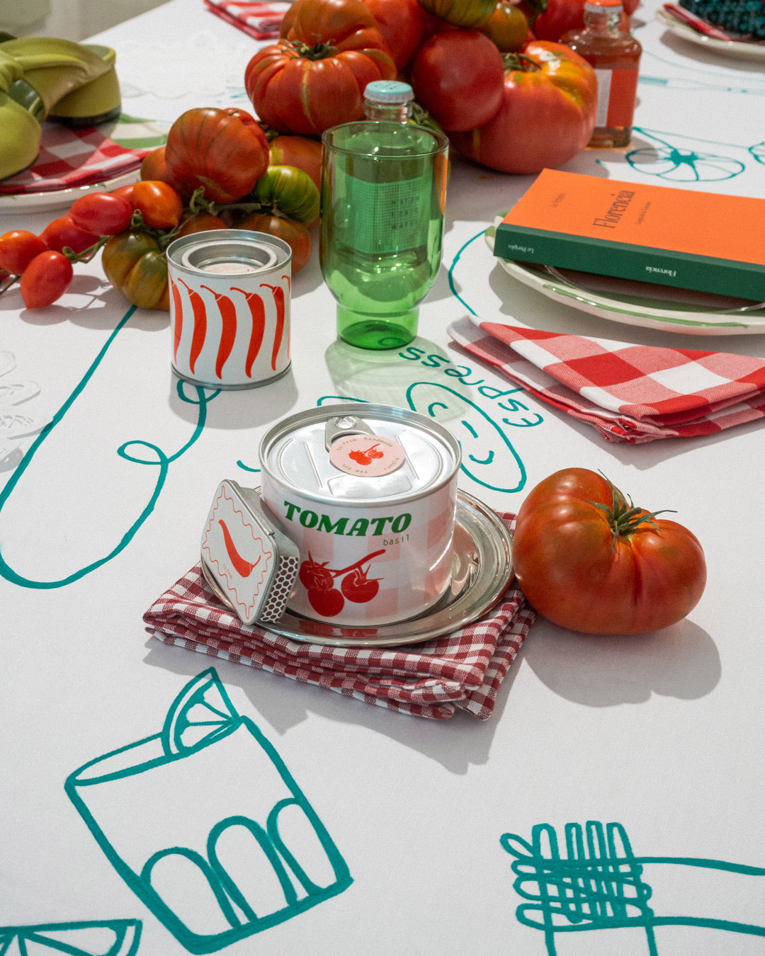 Mesa de presentación con temática italiana, tomates y decoración de productos de la tienda de Rugahra Haus y la guía de Florencia de Le Periplo