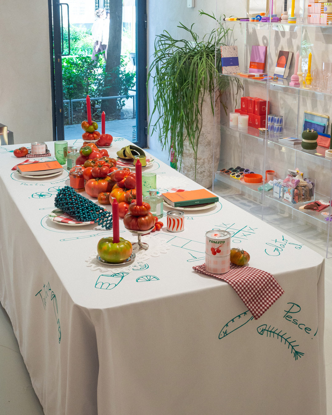 Instalación de mesa creada por Le Periplo y Casa Millvina con la temática de la última guía publicada Florencia, mesa llena de tomates con un mantel ilustrado a mano haciendo referencia a Italia