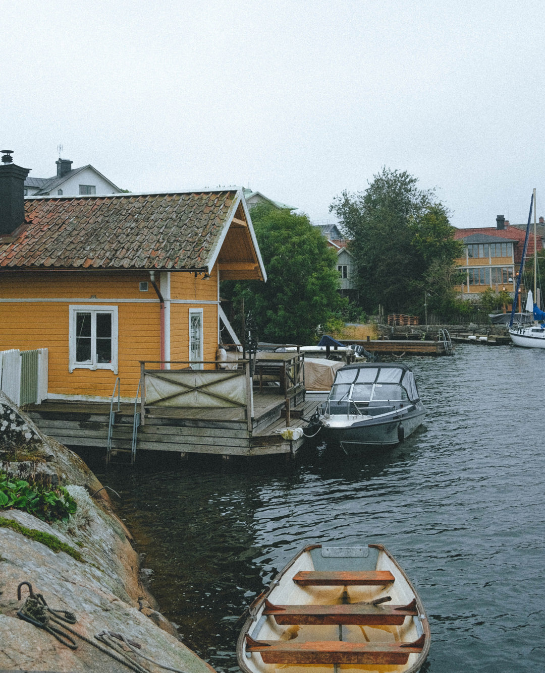 Guía de viaje de Estocolmo, recorrido por el archipiélago, recomendaciones para visitar Vaxholm, embarcadero tradicional en el archipiélago de Estocolmo, conexión en barco para explorar la ciudad como un local, paisaje nórdico costero, escapada desde Estocolmo entre casitas de madera y mar abierto.