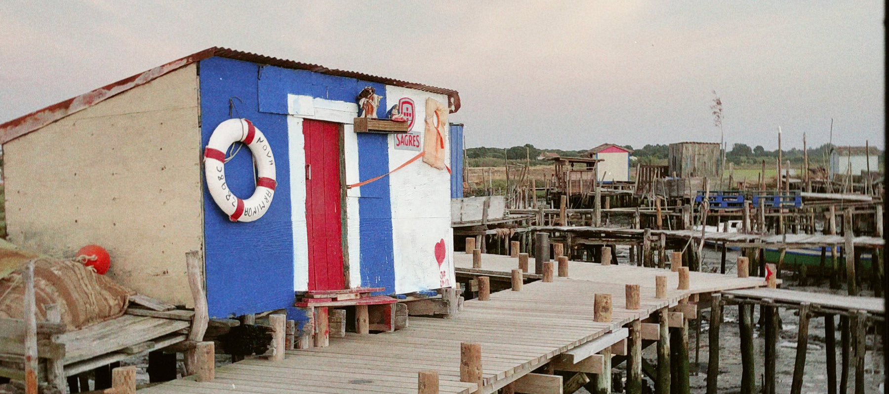 Cais Palafítico da Carrasqueira: Pasarela de madera sobre el agua en Carrasqueira, con barcas tradicionales amarradas.