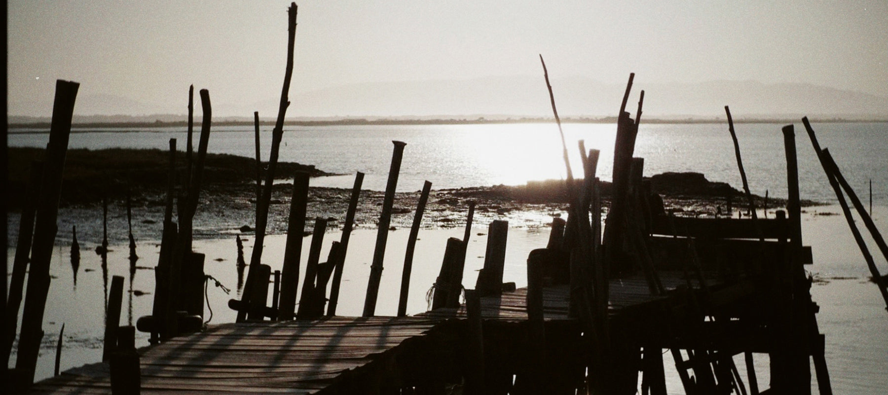 Carruajes en Cais Palafítico da Carrasqueira: Pasarela de madera sobre el agua en Carrasqueira, con barcas tradicionales amarradas.